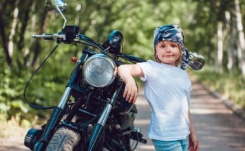 garçon à côté d'un 2 roues